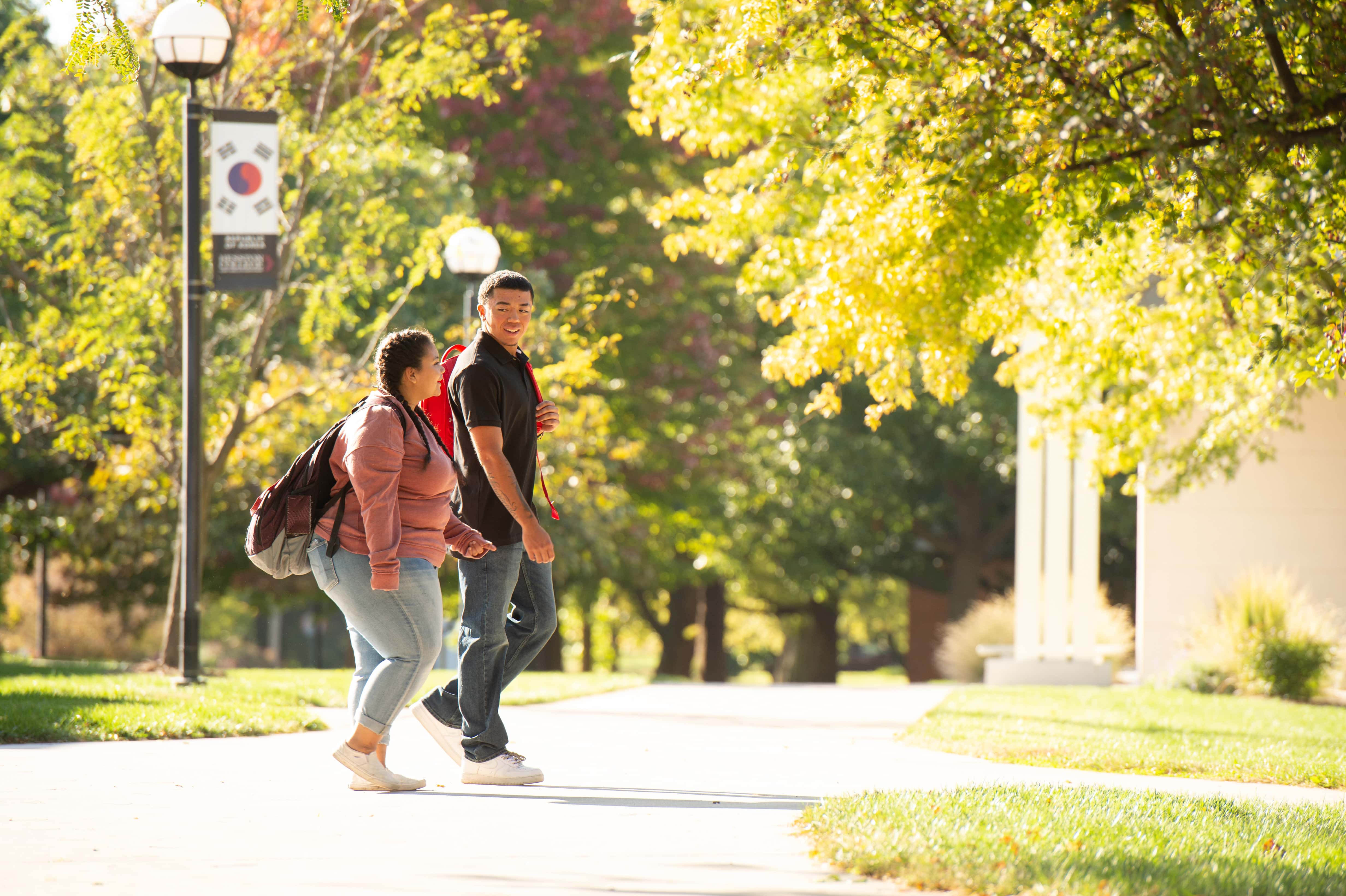Two students walking across campus
