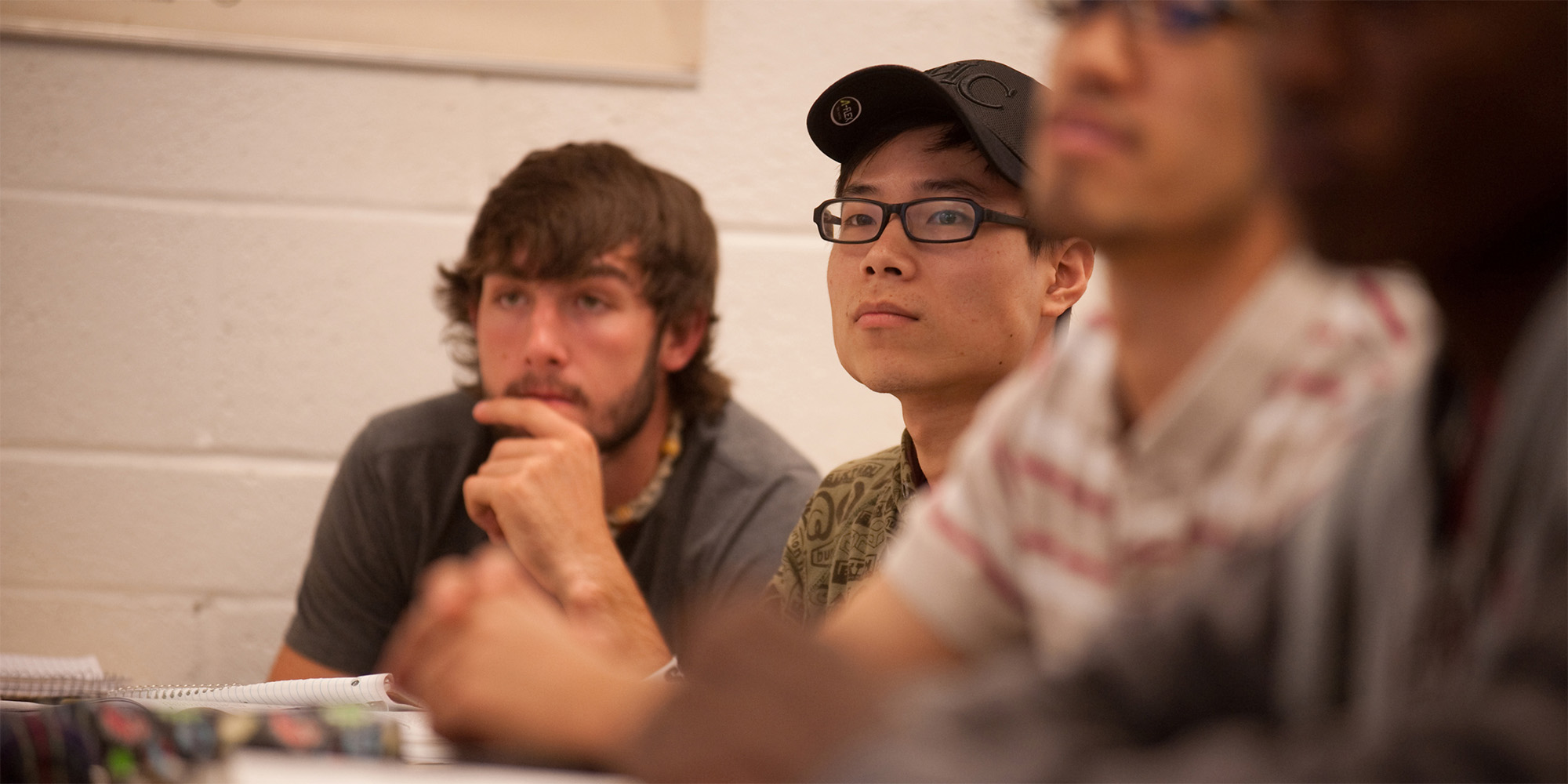 photo - Luke Ropp (Inman, Kan.) and Weihao Kong (Hefei, China) listen to precalculus instructor Jeff Baumgartner explain a concept during the spring 2012 semester.