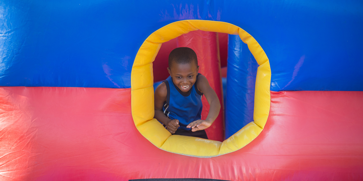 photo from homecoming kidfest 2017 - a child playing on an inflatable obstacle course