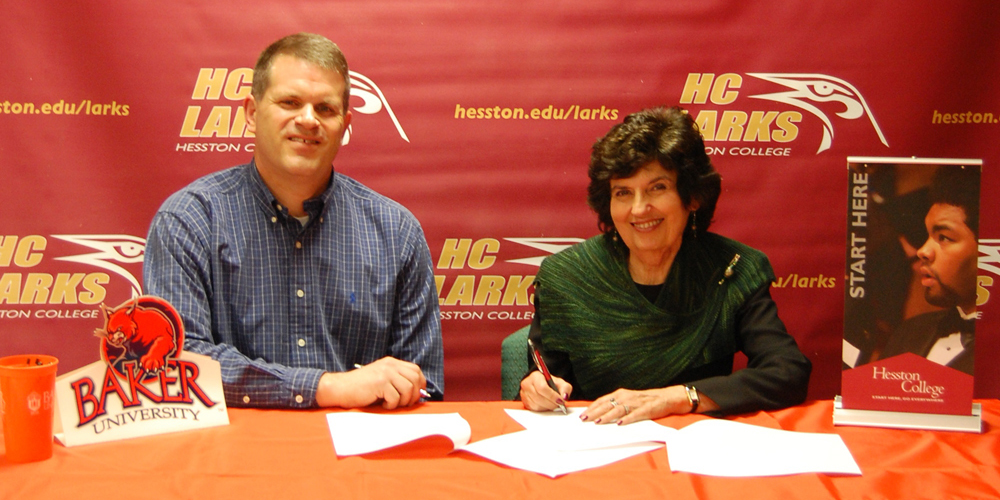 photo - Mark Bandre, Baker University director of transfer services, and Dr. Sandra Zerger, Hesston College vice president of academics sign an articulation agreement for transfer students from Hesston to Baker on the Hesston College campus April 12.