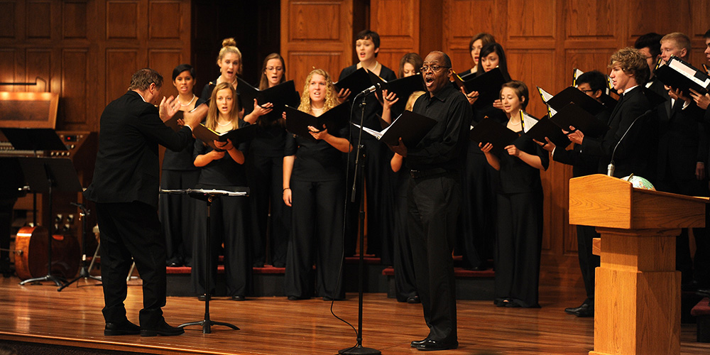 photo - Hesston College sociology instructor and artist in residence Tony Brown joins the Hesston College Bel Canto Singers, under the direction of Bradley Kauffman, for a song during the college’s Opening Celebration service Aug. 16.