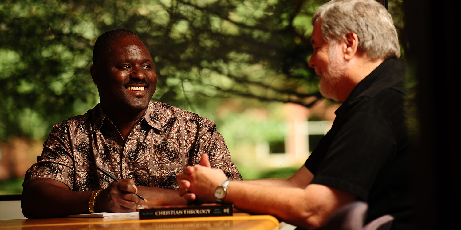 photo - Ron Moyo discusses class concepts with Tim Lichti, director of the Hesston College Pastoral Ministries program.
