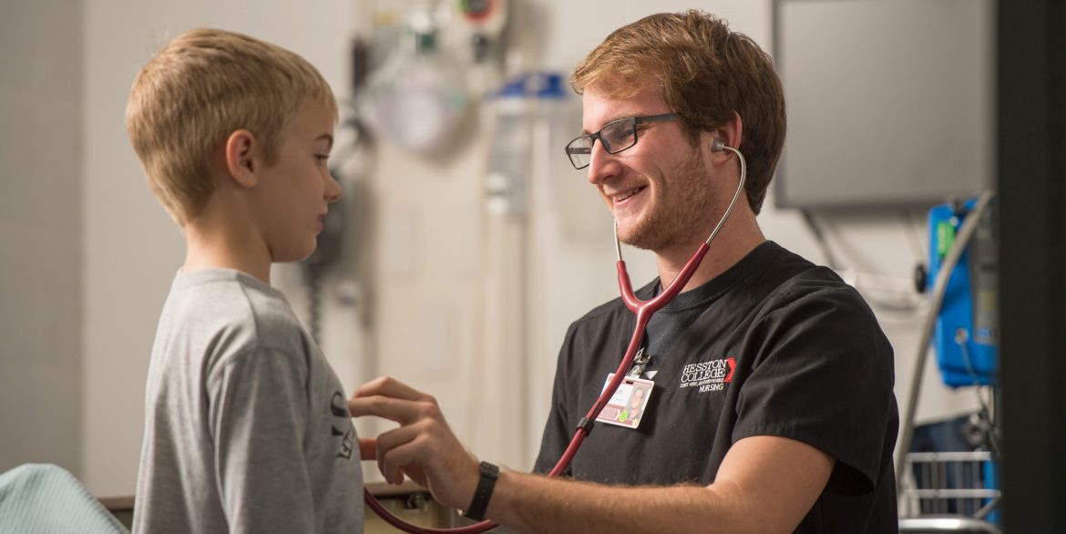 Photo: Hesston College promotional photo with a nursing student using a stethoscope to listen to a child's heart.