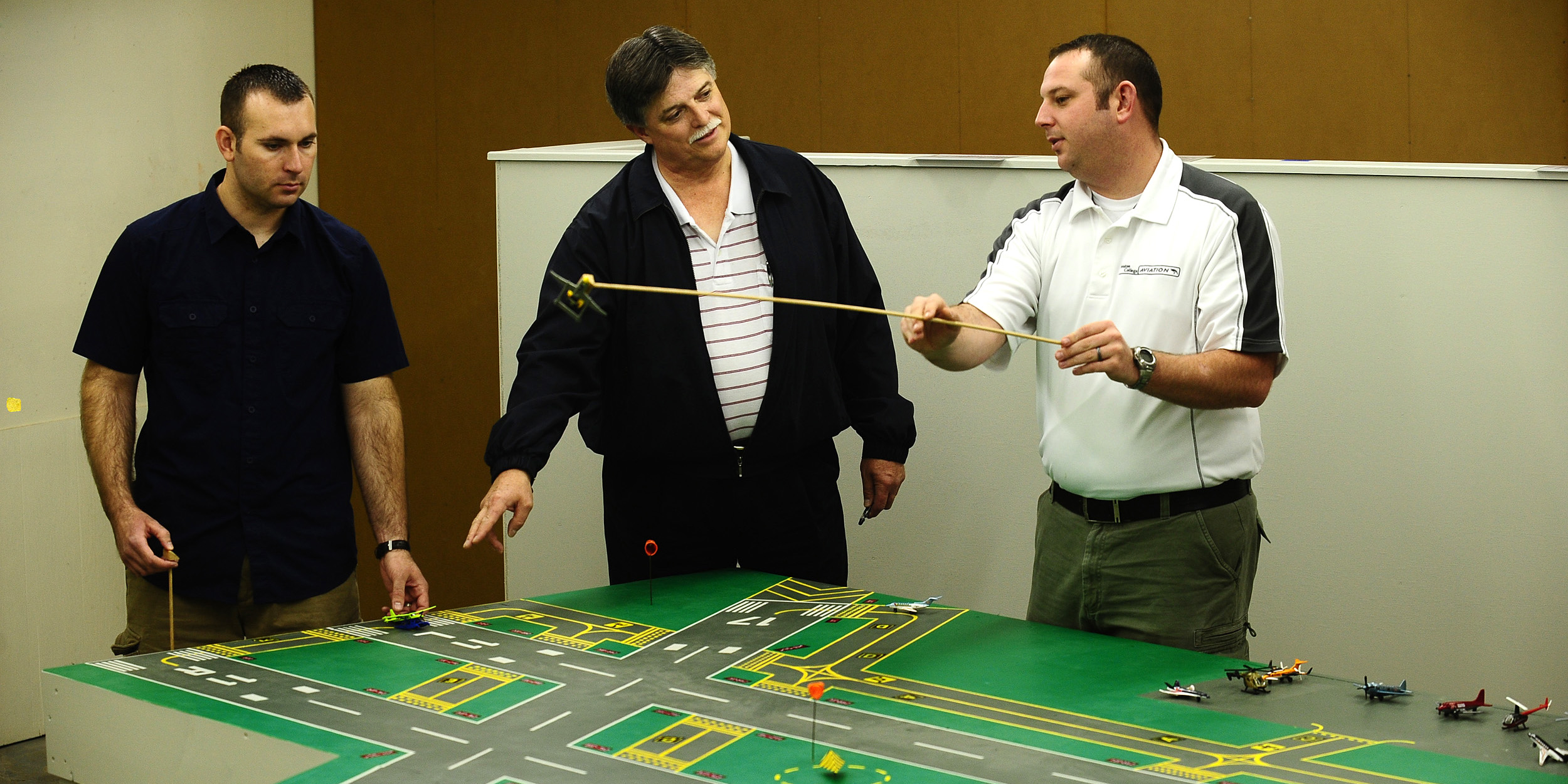 photo - Hesston College faculty member Dan Miller works with air traffic control students in the air traffic control lab.