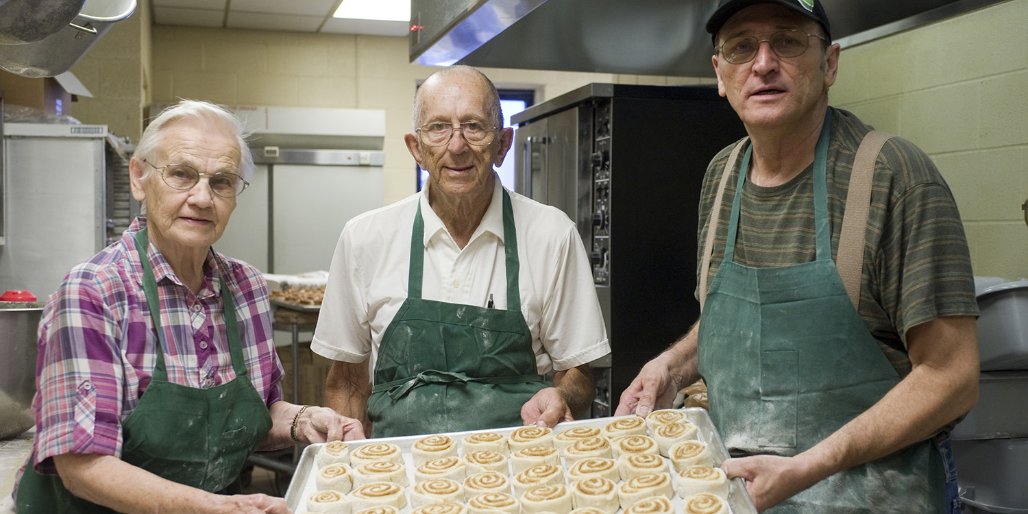 Minerva and Emil Yoder baking cinnamon rolls with Bob Nunemacher