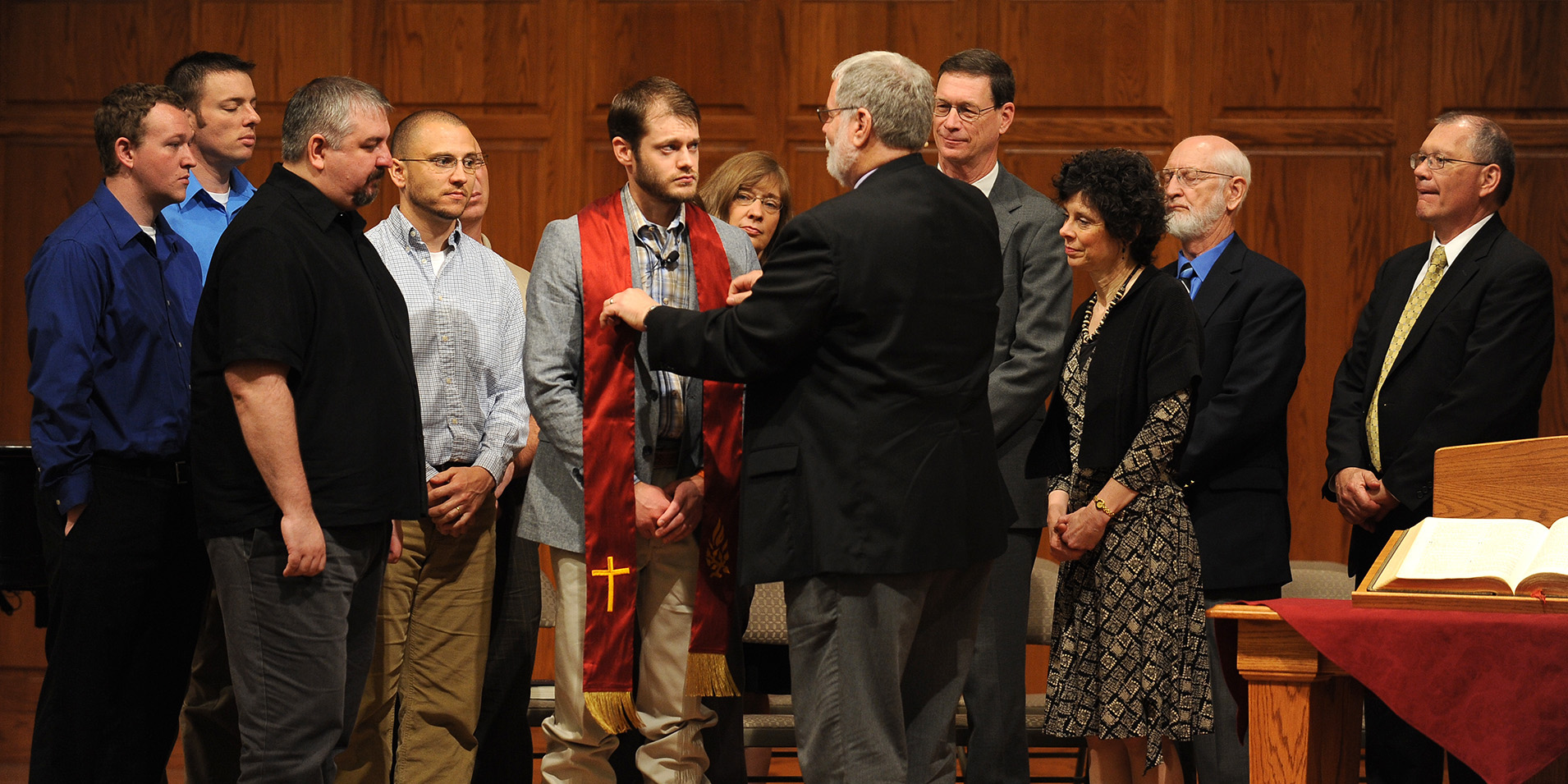 photo - Pastoral ministries graduate Kenzie Intemann, Bessie, Okla., receives his stole and a blessing from program director Tim Lichti.