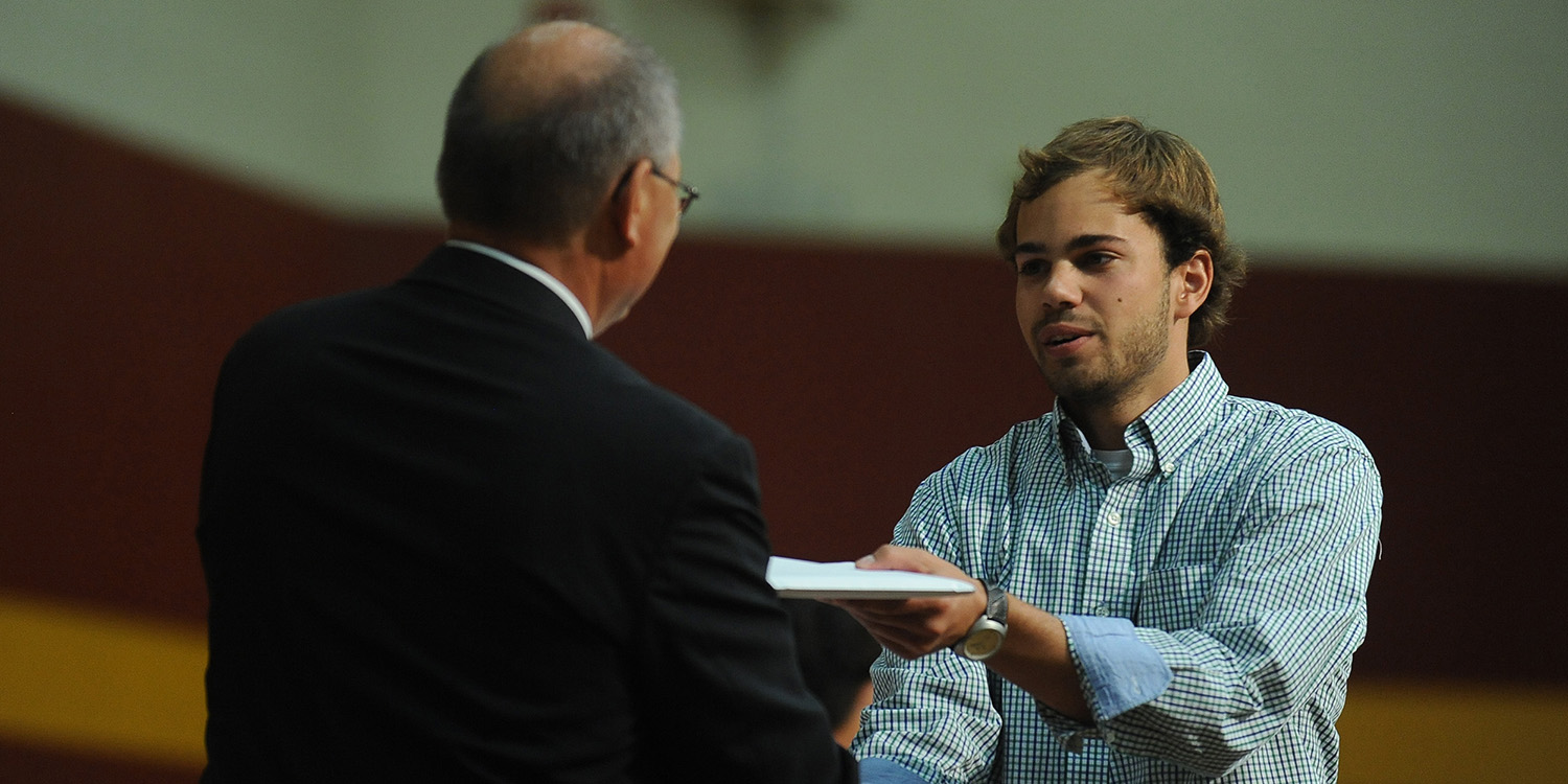 photo - Mitchell Martin (Milford, Neb.), receives his Hesston College diploma from President Howard Keim.