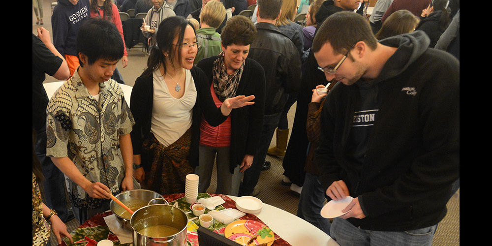 photo - Hesston College sophomore Victoria Gunawan (Semarang, Central Java, Indonesia) describes the Indonesian food she and freshman Kelvin Ferbianto (Jakarta, Indonesia) share with staff members Brenda Wenger and Michael Smalley at the Cultures Fair. International students and students from non-dominant North American cultures shared their customs and culture with the rest of the campus community during the celebration complete with food and performances of global music and dances. In past years, the college has hosted an International Festival for international students to share their culture with the campus. This year’s Cultures Fair was in place of that celebration and offered a more interactive atmosphere for participants.