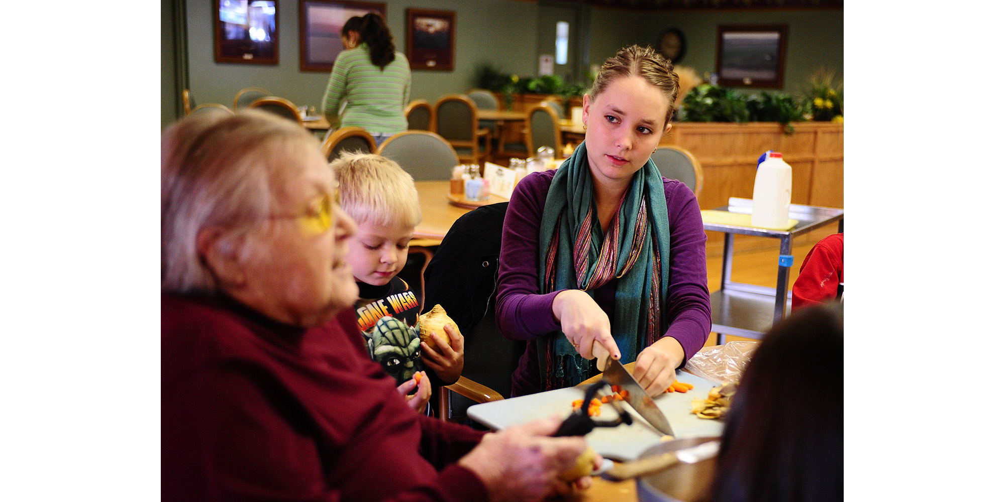photo - Kirsti Graffenberger (right) helps a resident with a presentation on the health benefits of rutabagas at Schowalter Villa as part of her cooperative learning experience.