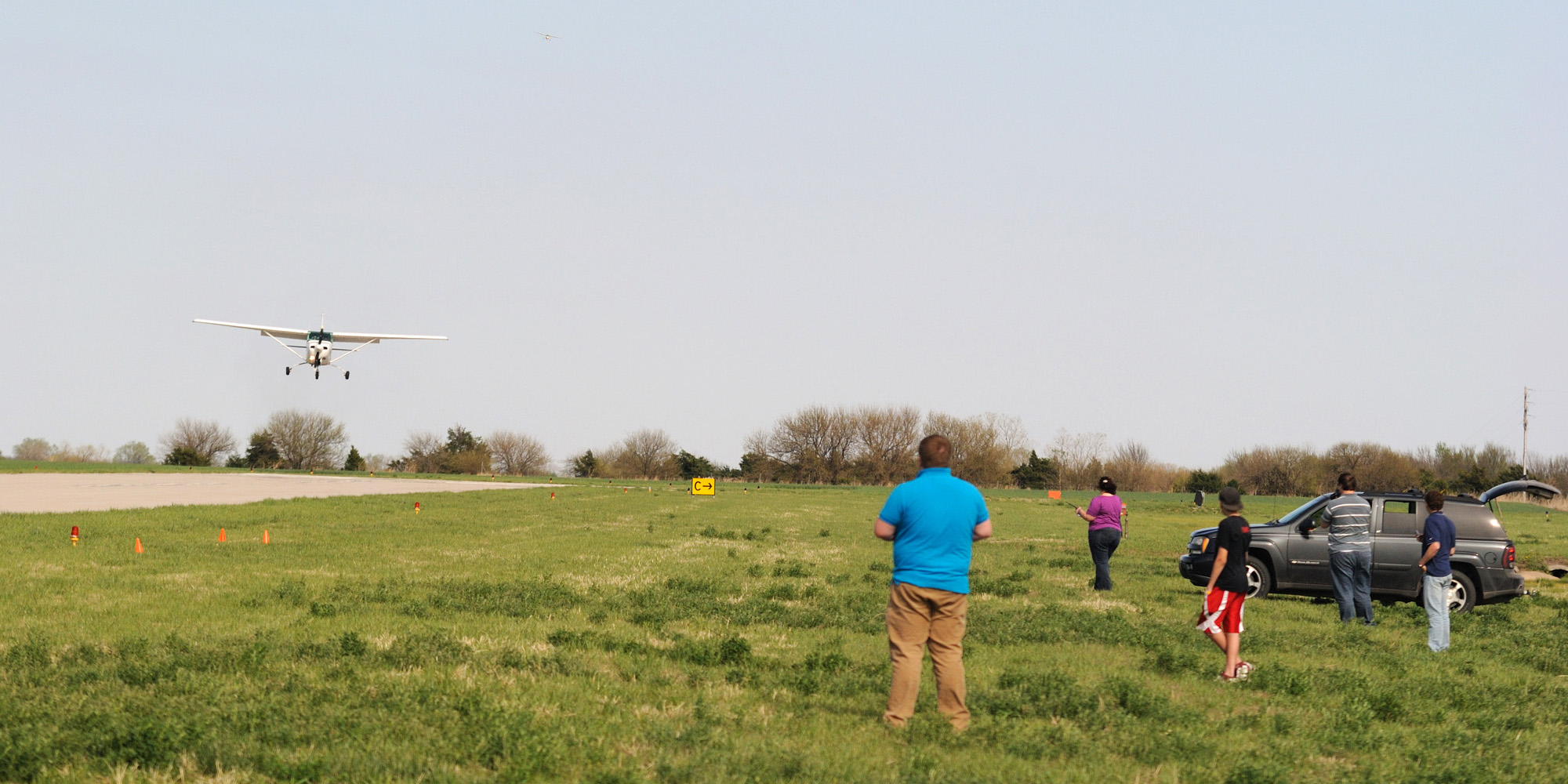 Hesston College flight instructors and onlookers watch approaching planes during the Aviation department’s annual Larks Flight Rally April 16 at the Newton City/County Airport. Aviation students and alumni competed in a flour bag drop competition and a landing competition. The day started with a presentation by Loren Groff, a 1991 Hesston College graduate and former Hesston flight instructor who is employed as a Transportation Safety Research Specialist at the National Transportation Safety Board in Washington D.C. Photo by Curtis Denlinger.