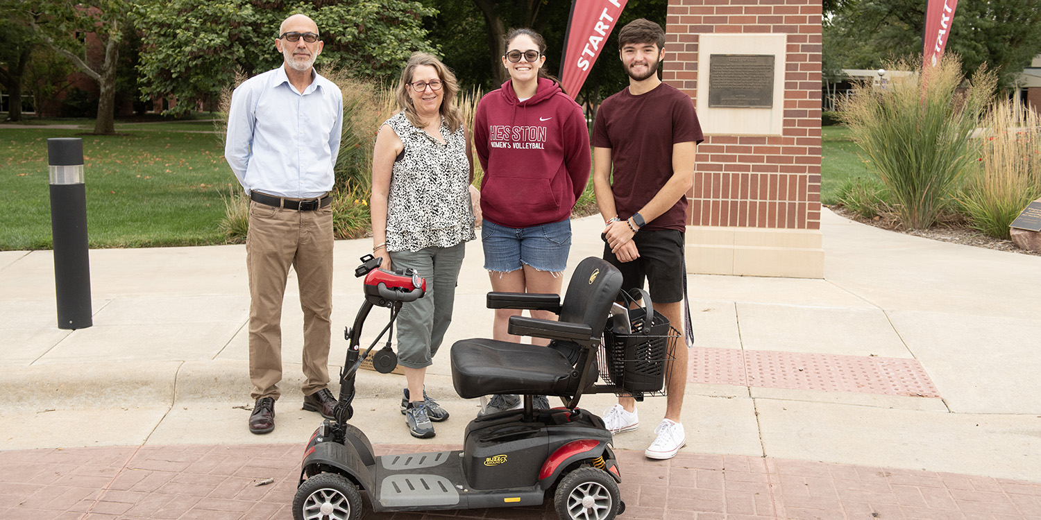 Students and professors posing for photo with scooter.