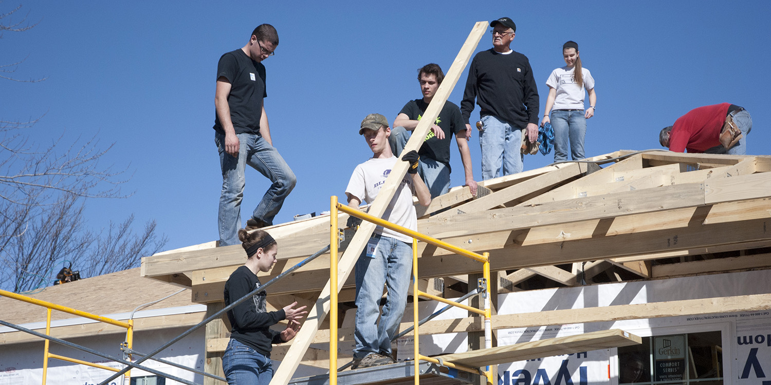 photo - A group of Hesston College students and other volunteers work on the roof of a house in Pilger, Neb., during the college's spring break