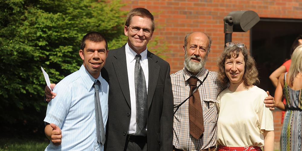 photo - Simon Zehr (left) celebrates his graduation with his academic advisor Russ Gaeddert (second from left) and his parents Dennis Zehr and Ellen Davis-Zehr.