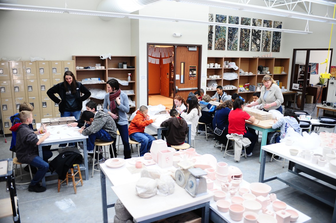 Marshall students design clay tiles on one of their tour stops. Hesston College art students and faculty will glaze and fire the tiles and incorporate them into a mosaic for the middle school.
