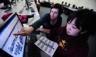 Communication faculty member Kendra Burkey works with a student on the yearbook staff.