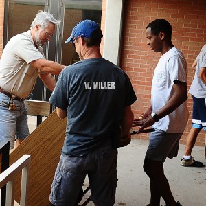 Hesston College Facilities staff Tim Goering and Forrest Miller and student Curtis Denlinger of Perkasie, Pa. move dressers from Erb Hall central and west.