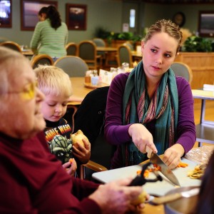 Kirsti Graffenberger (right) helps a resident with a presentation on the health benefits of rutabagas at Schowalter Villa as part of her cooperative learning experience.