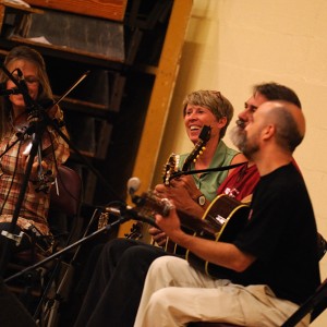 Gretchen Priest May, Dave Firestine and Tim May play live bluegrass music for the contra dance. Faculty member Jen LeFevre (second from left) was the caller for the evening.