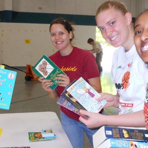 Hesston College students (from left) Evette Yoder (Phoenix, Ariz.), Anna Yoder (Garden City, Mo.), Carly Unruh (Wayland, Iowa) and Asbel Assefa (Addis Ababa, Ethiopia) package books for Ethiopia Reads during the campus packaging event sponsored by the African Student Union. Photo by Kendra Litwiller.