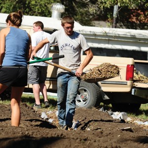 Jacob Landis works in the campus community garden. He brought methods and techniques he learned on the family farm for improved sustainability to campus.