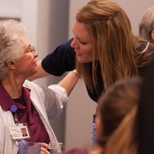 Nursing instructor Joyce Huber hugs a nursing alumna at a retirement break in Huber's honor.