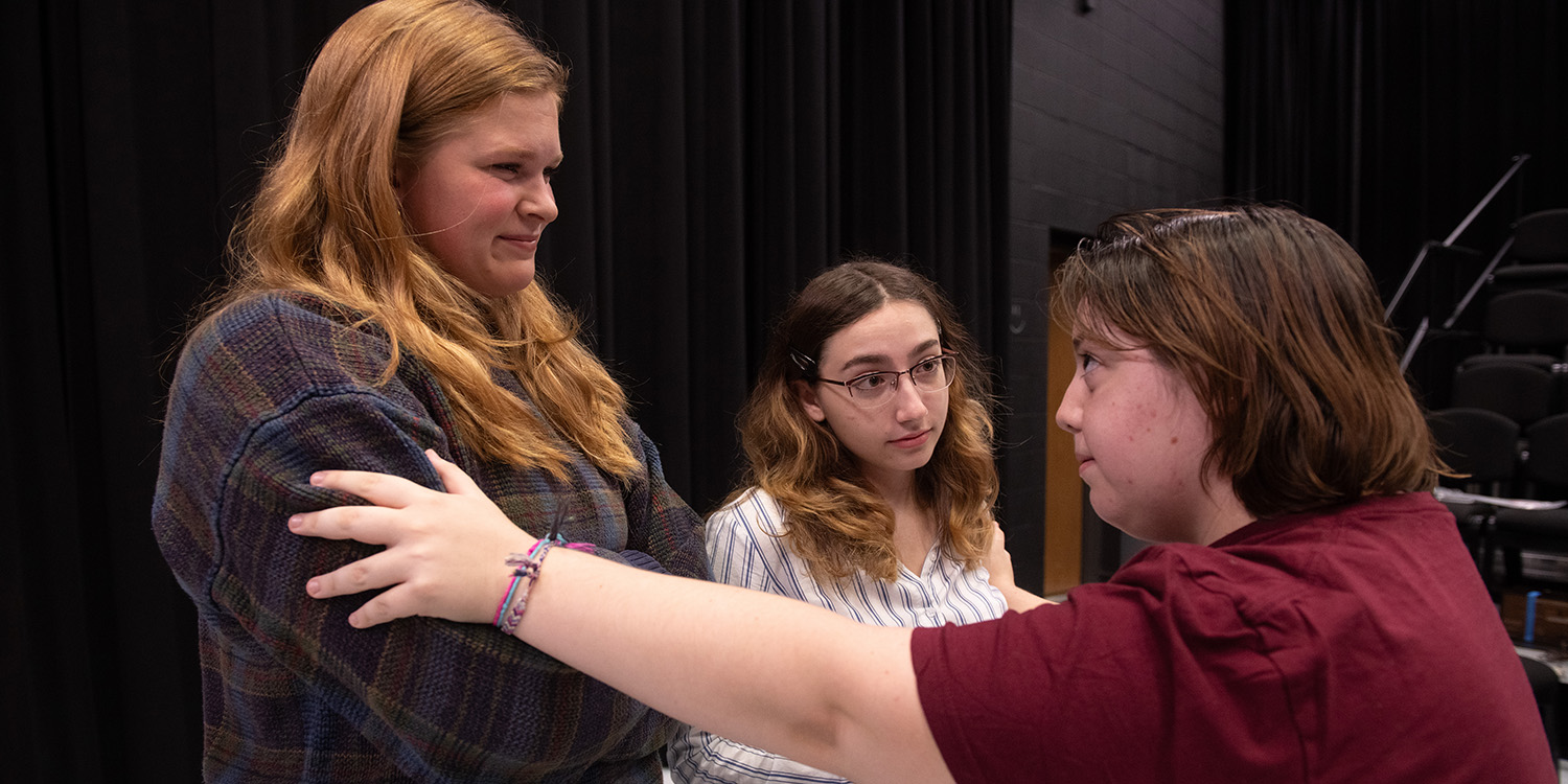 photo featuring three actors rehearsing for the Hesston College production of "Antigone"