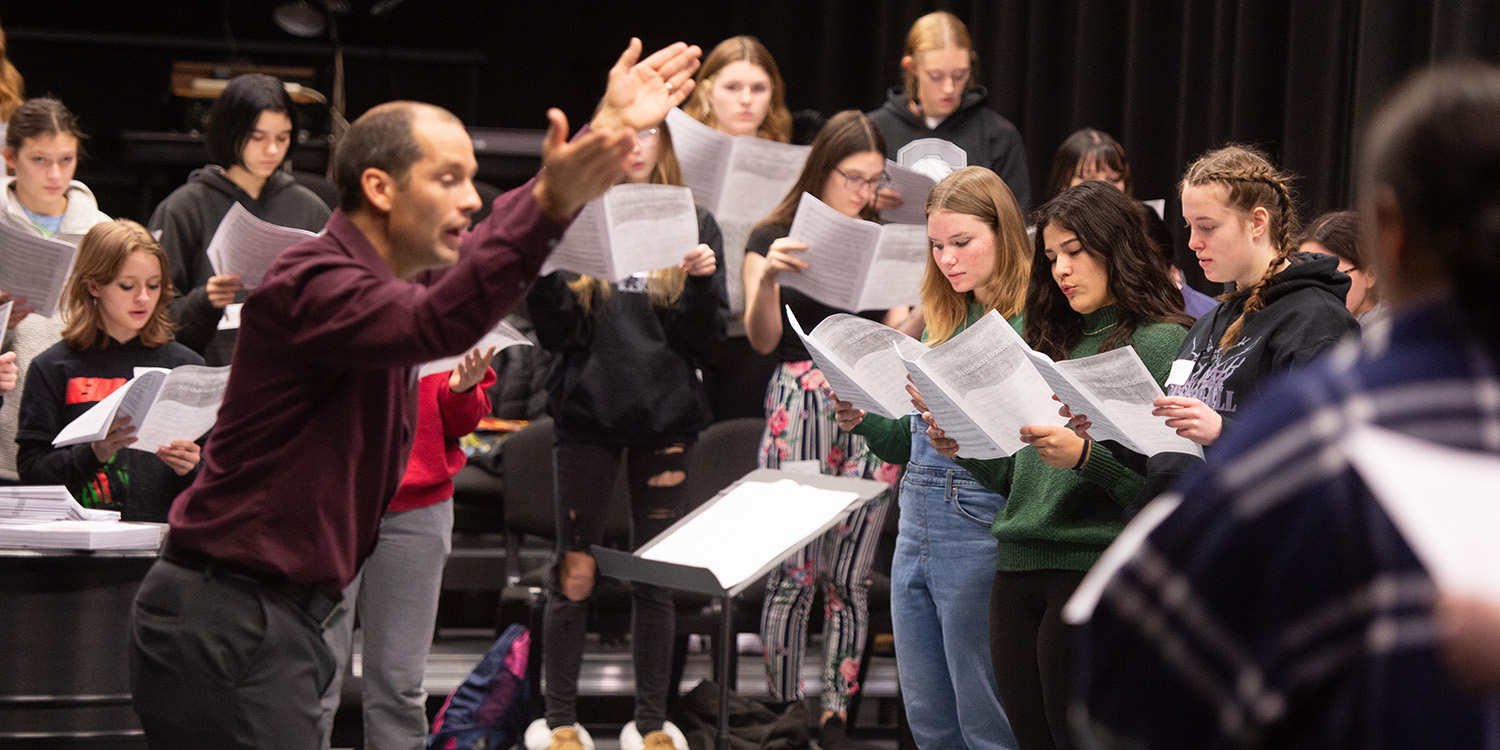 photo of high school singers rehearsing under the direction of Dr. Russell Adrian at Treble Choral Festival 2023